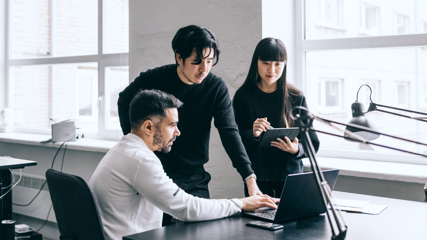 Team working around a laptop